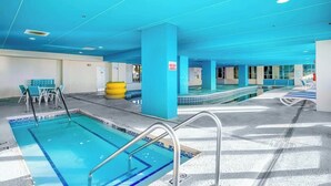 A swimming pool area with multiple lanes, a lounge area with chairs, and a yellow exercise ball. - Bay Watch Resort 0919 (North Myrtle Beach)
