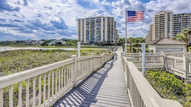 Een houten looppad naar hoge gebouwen, met een Amerikaanse vlag.