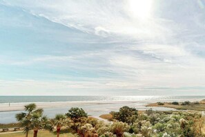Eine Küstenlandschaft mit Strand, Palmen und blauem Himmel.