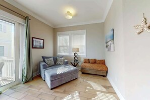 A living room with a grey sofa, a smaller grey couch, a lamp, and a picture on the wall. - Seas the Day Retreat (Myrtle Beach)
