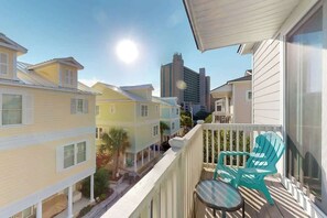 A balcony with a view of neighboring buildings and a clear sky. - Seas the Day Retreat (Myrtle Beach)