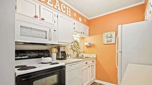 A kitchen with white cabinets, a microwave, a stove, a dishwasher, and a refrigerator. - Waipani Unit D-10 Condo (North Myrtle Beach)