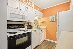 A kitchen with white cabinets, a microwave, a stove, a dishwasher, and a refrigerator. - Waipani Unit D-10 Condo (North Myrtle Beach)