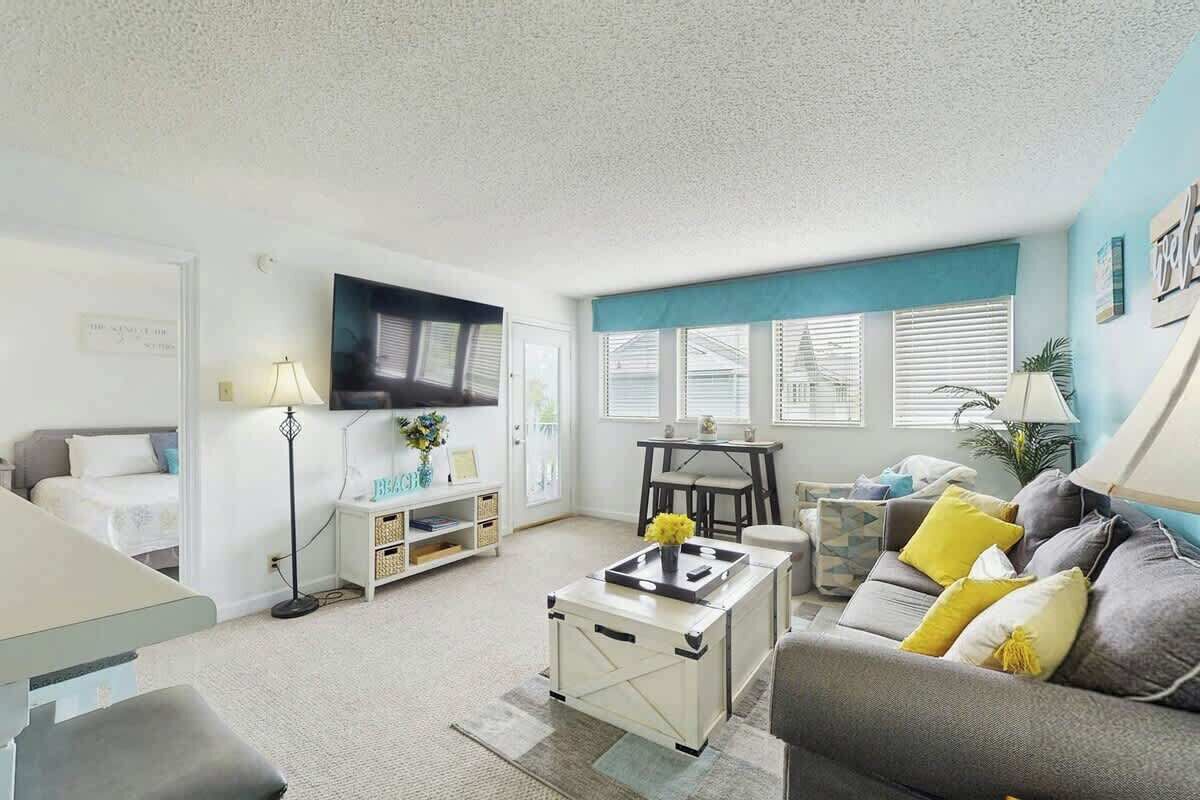 A living room with a sofa, coffee table, and a television.