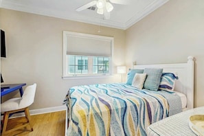 A bedroom with a bed, a desk, a chair, and a ceiling fan. - Seaside Sanctuary at Litchfield by the Sea (Pawleys Island)