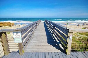 A wooden boardwalk leading to a beach with a sign indicating no beachside lighting from May to October. - Seaside Sanctuary at Litchfield by the Sea (Pawleys Island)