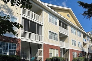 A multi-story residential building with balconies, large windows, and a brick facade. - Barefoot Landing Beach and Golf  Resort Villa (North Myrtle Beach)
