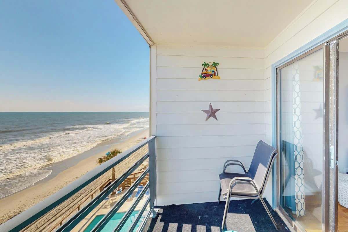 Un balcon avec vue sur la plage, une chaise et une décoration en forme d’étoile.