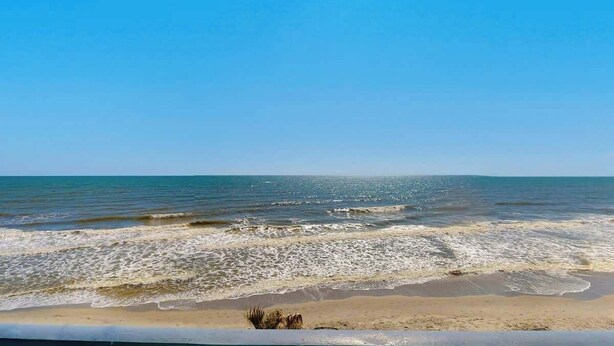 A beach with waves and a clear sky. - Paradise Palms Retreat (Murrells Inlet)