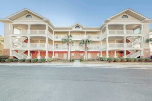 Ein mehrstöckiges Hotel mit Balkonen, einer Ziegel-Fassade und einem zentralen Eingang.