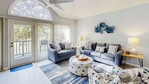 A spacious living room with two sofas, a coffee table, and a patterned ottoman. - Tidewater Dream Retreat (North Myrtle Beach)