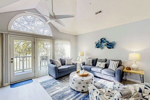 A spacious living room with two sofas, a coffee table, and a patterned ottoman. - Tidewater Dream Retreat (North Myrtle Beach)
