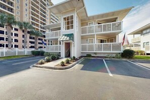 A multi-story hotel with balconies, a flag, and a parking area. - Shorehaven II Unit - 2C (North Myrtle Beach)