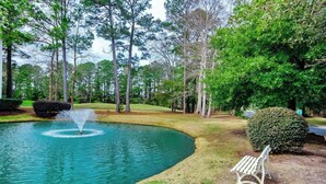 A tranquil outdoor area with a fountain, a bench, and a well-maintained lawn. - The Fairways Unit 19D (Myrtle Beach)