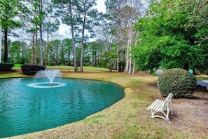 A tranquil outdoor area with a fountain, a bench, and a well-maintained lawn. - The Fairways Unit 19D (Myrtle Beach)