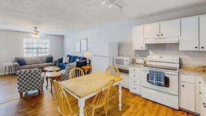A compact living space with a kitchenette, a dining area, and a seating area with a sofa and chairs. - 3rd Avenue Oasis Retreat (North Myrtle Beach)