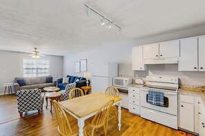 A compact living space with a kitchenette, a dining area, and a seating area with a sofa and chairs. - 3rd Avenue Oasis Retreat (North Myrtle Beach)