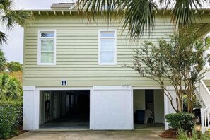 Un bâtiment à deux étages doté d’une entrée de garage, d’un petit porche et d’un panneau indiquant une entrée accessible aux personnes handicapées.