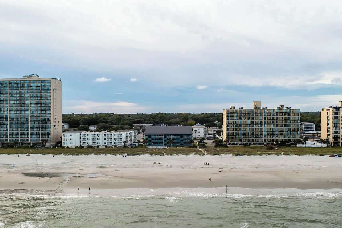Vista costera con edificios frente al mar y una playa de arena.