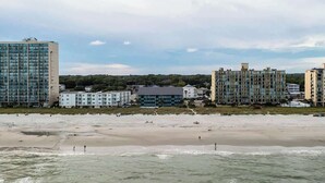 Vistes de la costa amb edificis a peu de platja i una platja sorrenca.