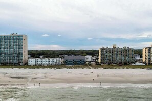 Ein Küstenblick mit Gebäuden direkt am Strand und einem Sandstrand.
