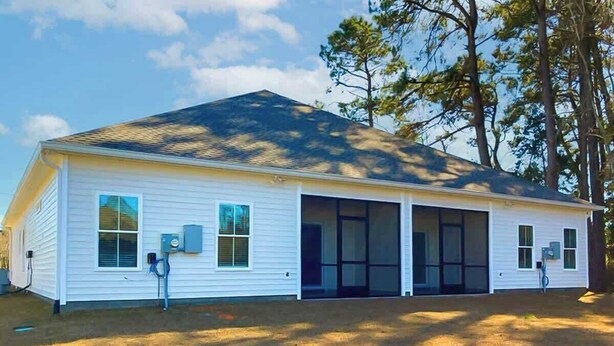 A single-story building with a garage, large windows, and a covered porch area. - Cocora on Church Street - A (Myrtle Beach)