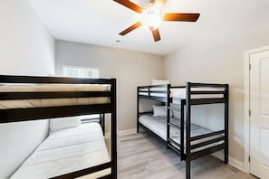 A room with bunk beds, a ceiling fan, and a window. - Cocora on Church Street - A (Myrtle Beach)