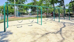 A playground with swings and a sand area. - Myrtle Beach Resort  A-306 (Myrtle Beach)