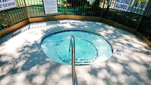 A circular pool with a metal handrail, surrounded by a concrete deck and a metal fence. - Myrtle Beach Resort  A-306 (Myrtle Beach)
