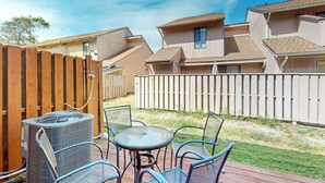 Un quartier résidentiel doté d’une terrasse, de mobilier d’extérieur et d’un grand climatiseur.