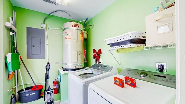 Une buanderie équipée d’un lave-linge, d’un sèche-linge et d’un chauffe-eau.