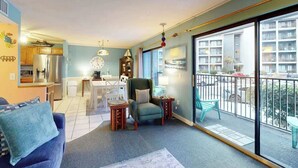 A living room with a sofa, a chair, a small table, and a balcony with a railing. - The Golden Sailboat B-139 (Myrtle Beach)