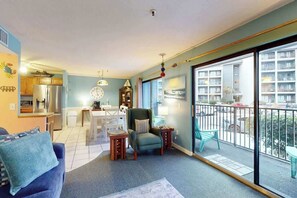 A living room with a sofa, a chair, a small table, and a balcony with a railing. - The Golden Sailboat B-139 (Myrtle Beach)