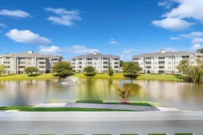 A multi-story residential building with a courtyard and a pond. - Turtle Cove Unit #204 (Myrtle Beach)