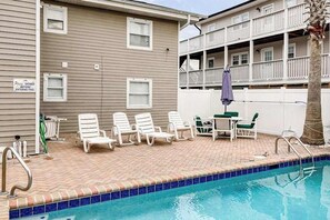 A swimming pool area with lounge chairs and a sign instructing to shower before entering the pool. - Seahorse Serenity Retreat (North Myrtle Beach)