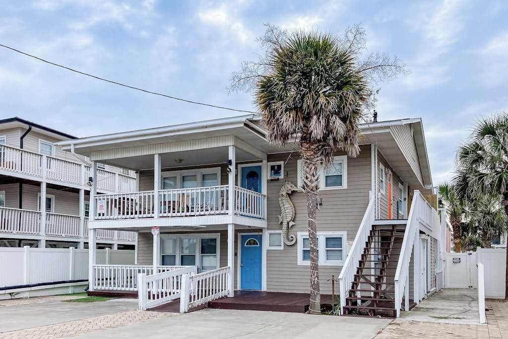 A two-story building with a balcony on the ground floor and a staircase leading to the second floor.