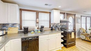 A kitchen with a dishwasher, stove, and coffee maker. - Seahorse Serenity Retreat (North Myrtle Beach)