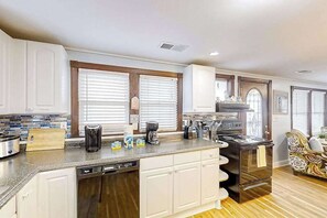 A kitchen with a dishwasher, stove, and coffee maker. - Seahorse Serenity Retreat (North Myrtle Beach)