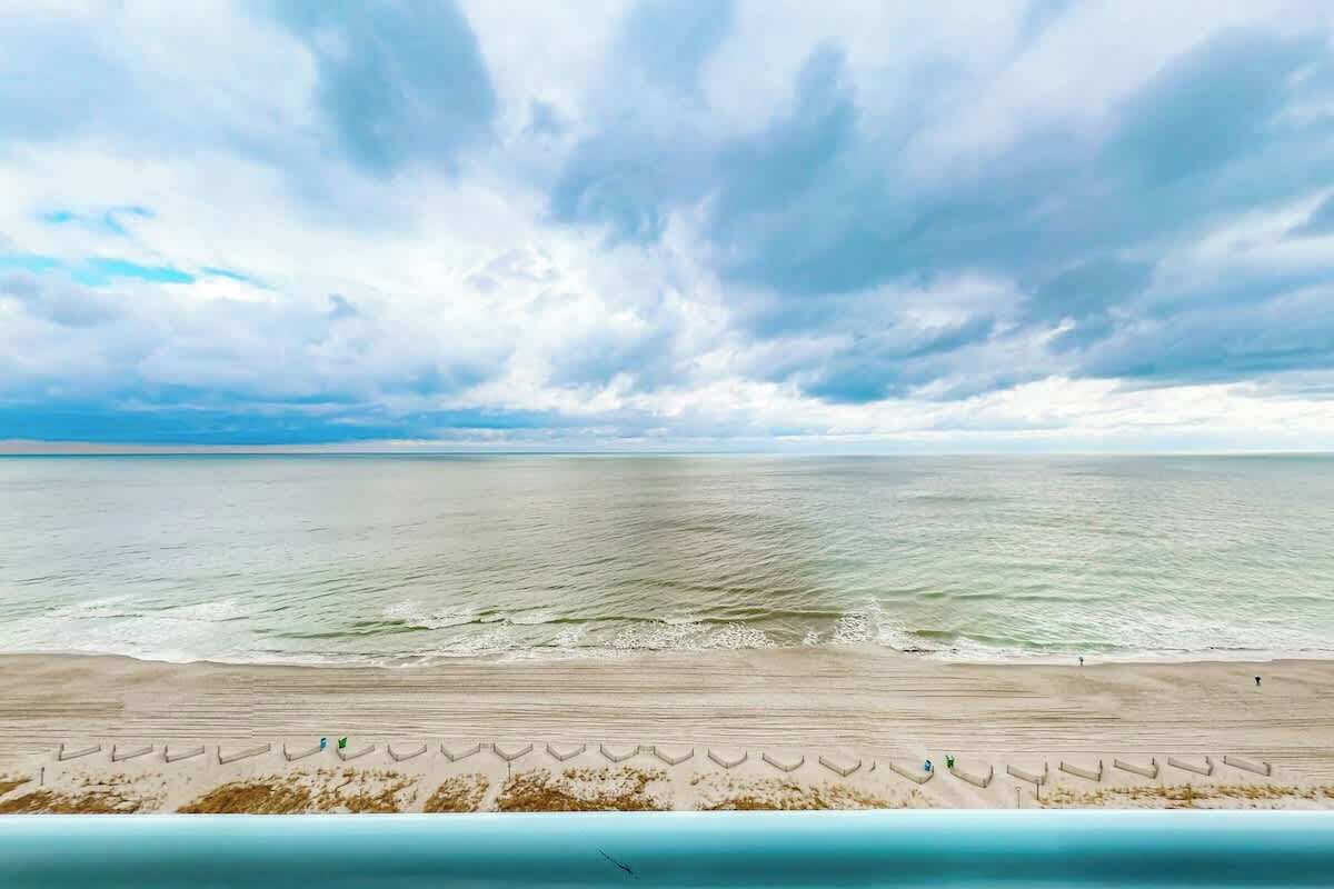 A beach with a clear view of the ocean and sky.