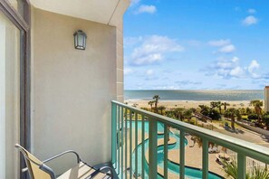 Ein Balkon mit Blick auf Strand und Pool.