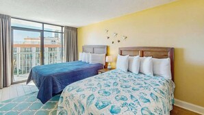 Ein Hotelzimmer mit zwei Betten, einem Balkon und Blick auf die Stadt.
