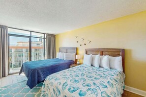 Ein Hotelzimmer mit zwei Betten, einem Balkon und Blick auf die Stadt.