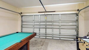 Een pooltafel met een groene viltkleed, een houten zijkant en een metalen rand.