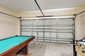Ein Billardtisch mit grüner Spielvliesbahn, einer Holzseite und einer Metalllaufbahn.