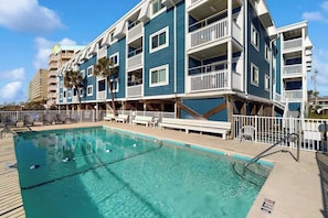 A hotel with a pool, multiple balconies, and a view of the ocean. - Ocean Wave Retreat Home (North Myrtle Beach)