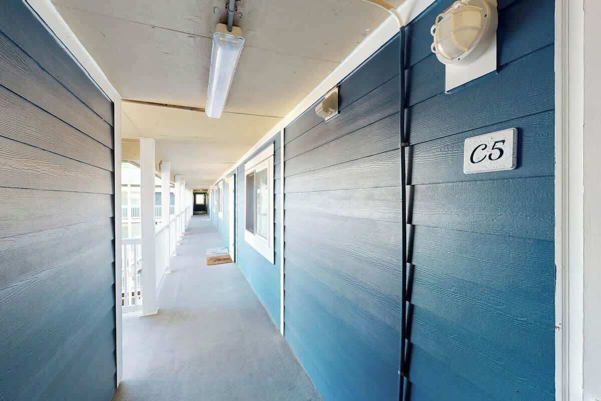 Ein Korridor mit blauer Wand und weißer Tür, auf der 'C5' steht.