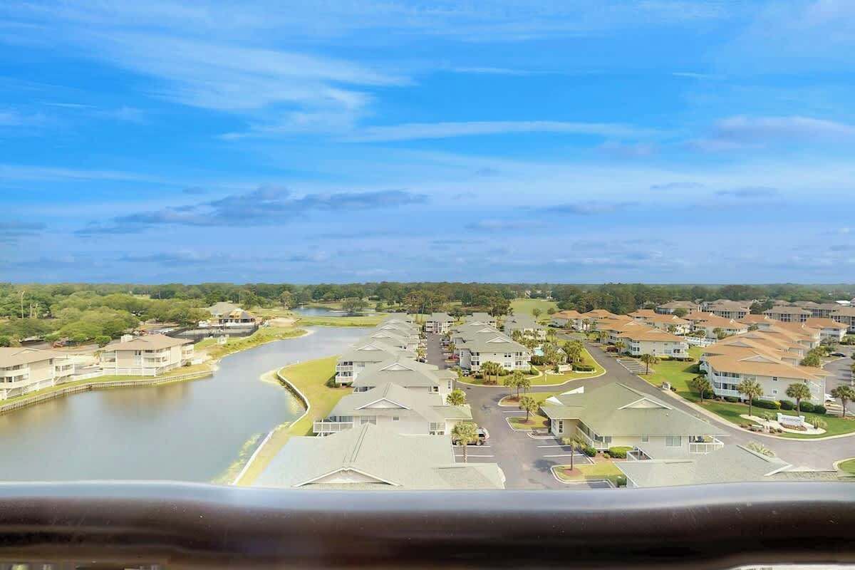 A residential area with houses, a river, and a clear sky.