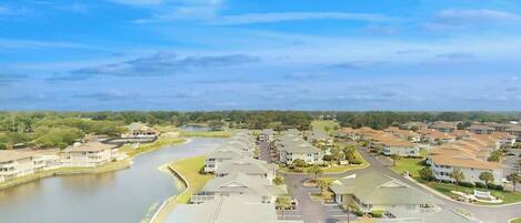 A residential area with houses, a river, and a clear sky.