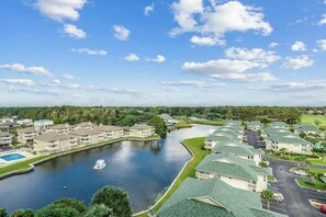 Un quartier résidentiel comprenant plusieurs immeubles d’appartements, un plan d’eau et une fontaine.