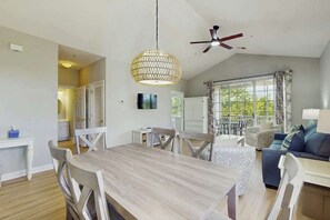 A spacious living area with a dining table, chairs, a sofa, and a ceiling fan. - Starfish Retreat at The Havens 1434 (North Myrtle Beach)